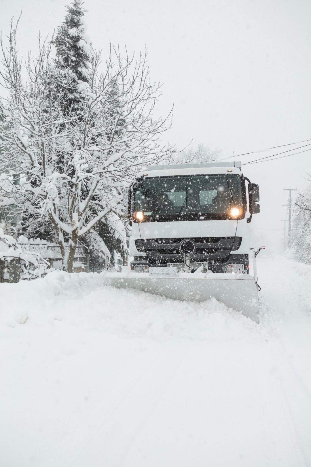 Snow plow removing snow from street.